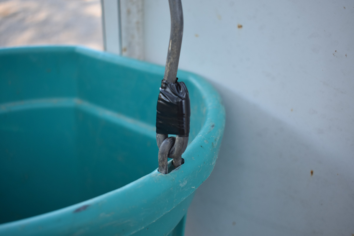 Electric tape on a bucket handle which is a barn hack for safety